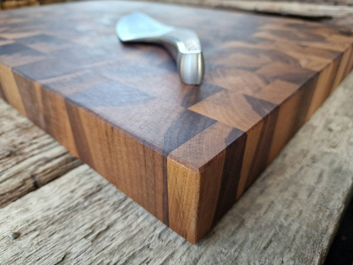 Eckansicht eines Nussbaum Hirnholz Schneideblockes mit einem Güde Kochmesser.