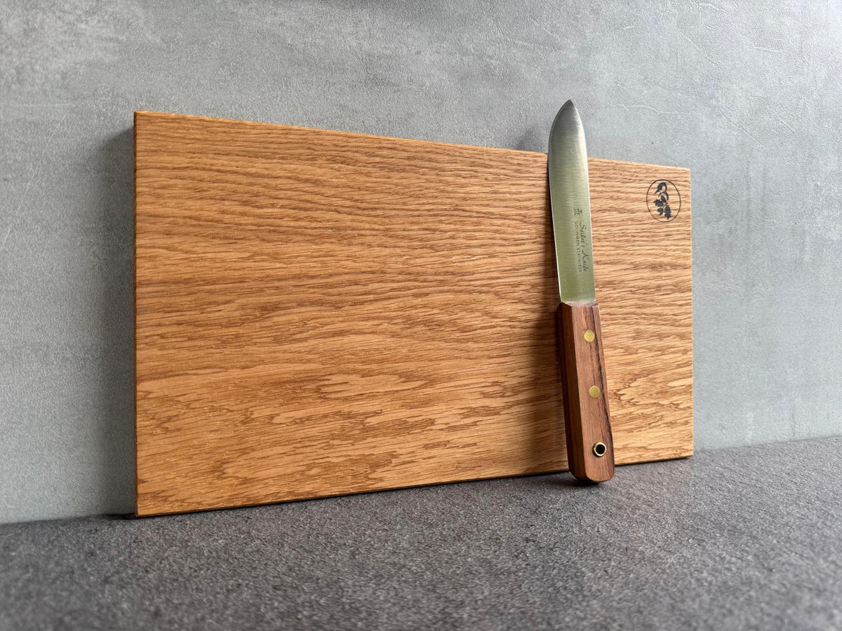 Detailaufnahme der Brettkante mit Messer, Struktur und Ölglanz sichtbar.