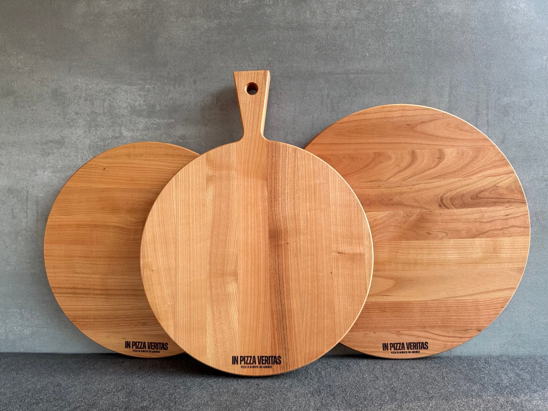 Runde Pizzabretter aus Kirschholz mit feiner Gravur „In Pizza Veritas“.
Erhältlich in 35 cm und 40 cm, mit oder ohne Griff.