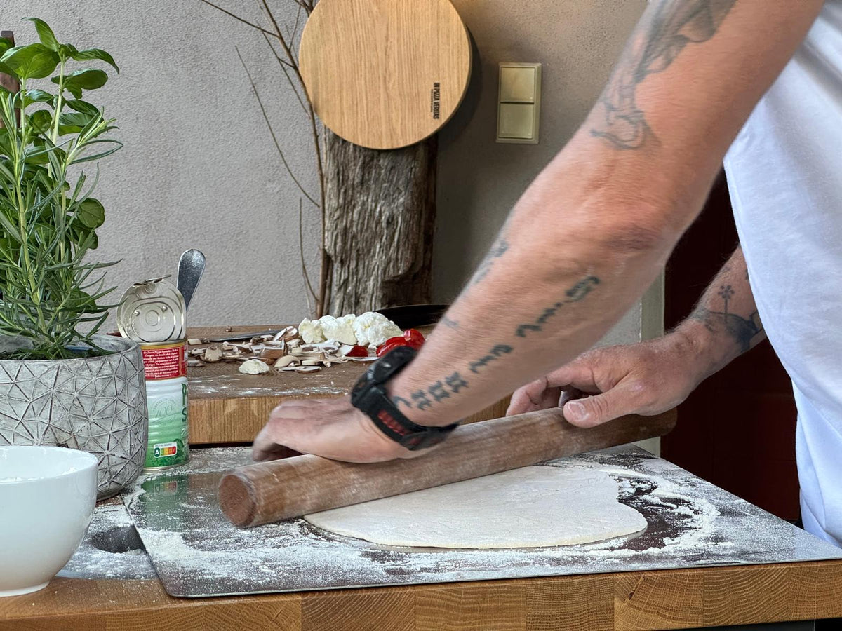 Pizzateig und Teigrolle auf einem Edelstahlbackblech von Gi.Metal