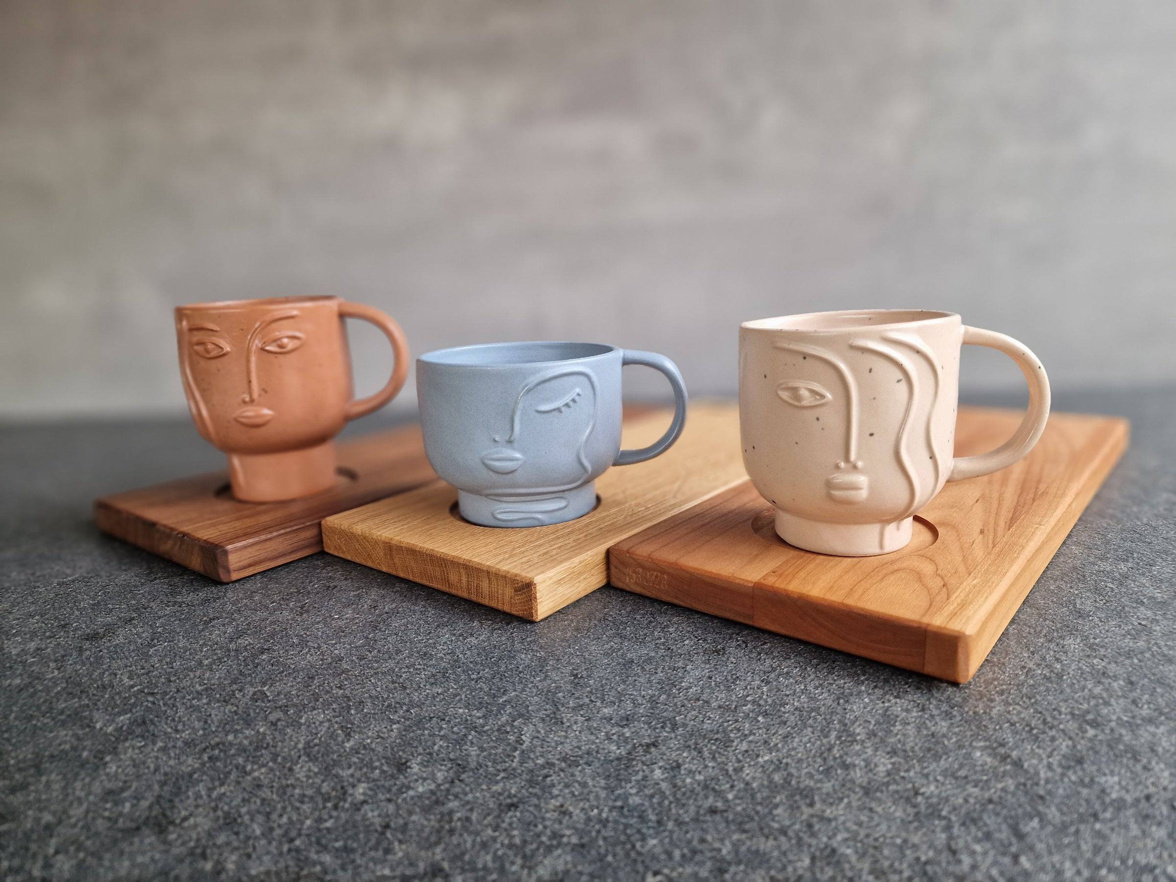 Dreierlei Holz Tabletts mit Tassenmulde aus Eiche, Kirschbaum und Nussbaum. Jeweils mit einer großen Tasse dekoriert.