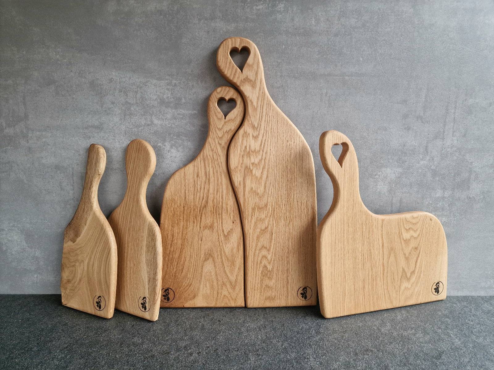 Partnerbretter mit Geschwisterbretter aus massiver Eiche. 5 Unikat Holzbretter an einer Betonwand.