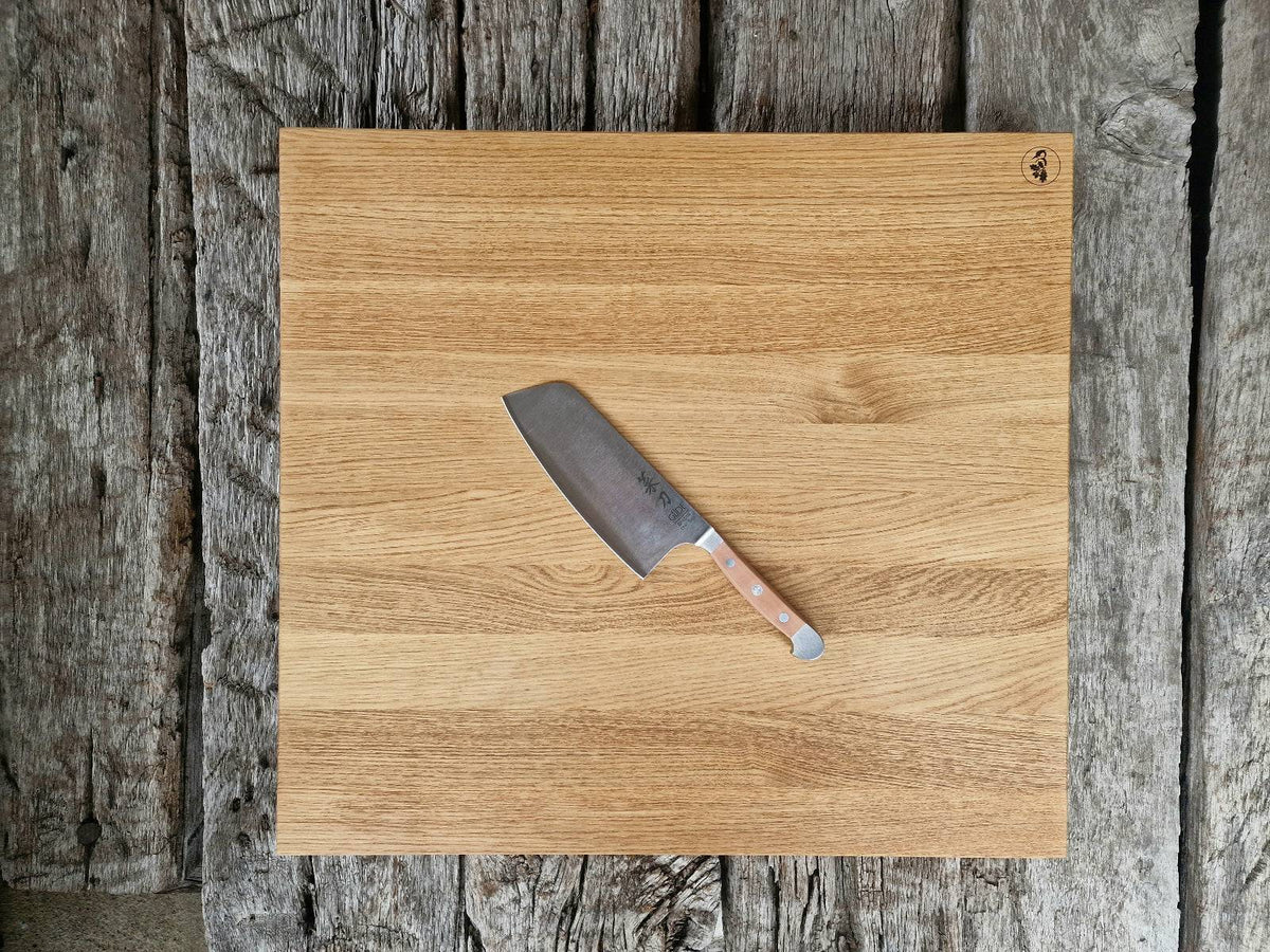60 cm großer Eiche Schneideblock auf alten Eichenbalken. Dekoriert mit einem Güde Kochmesser Alpha mit Birne Griff.