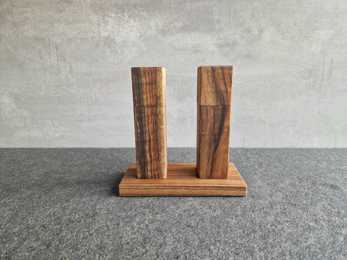 Dieselbe Salzmühle und Pfeffermühle im Set mit Mahlwerk von der Firma Strässler. Dekoriert auf einem Ovengkol Mühlen Teller.