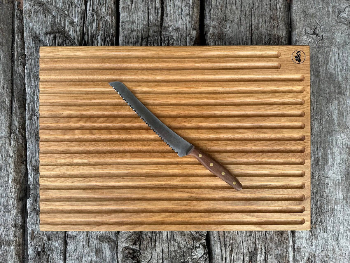 Großes Brotbrett in der Größe 60 x 40 cm  aus massiver Eiche auf alten Eichenbalken. Dekoriert mit einem Brotbeidhänder von Windmühlenmesser.