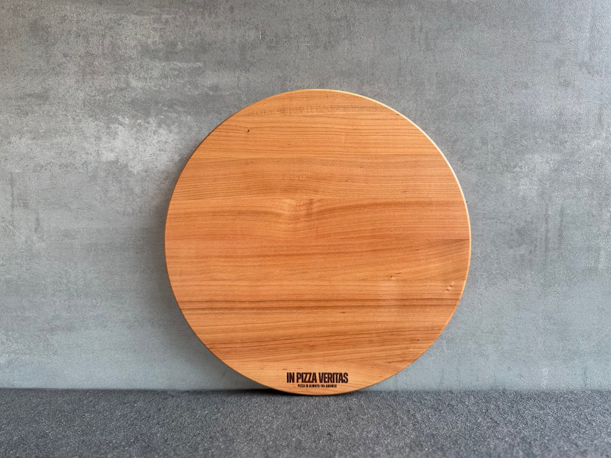 Rundes Pizzabrett aus Kirschholz mit feiner Gravur „In Pizza Veritas“.
Erhältlich in 35 cm und 40 cm