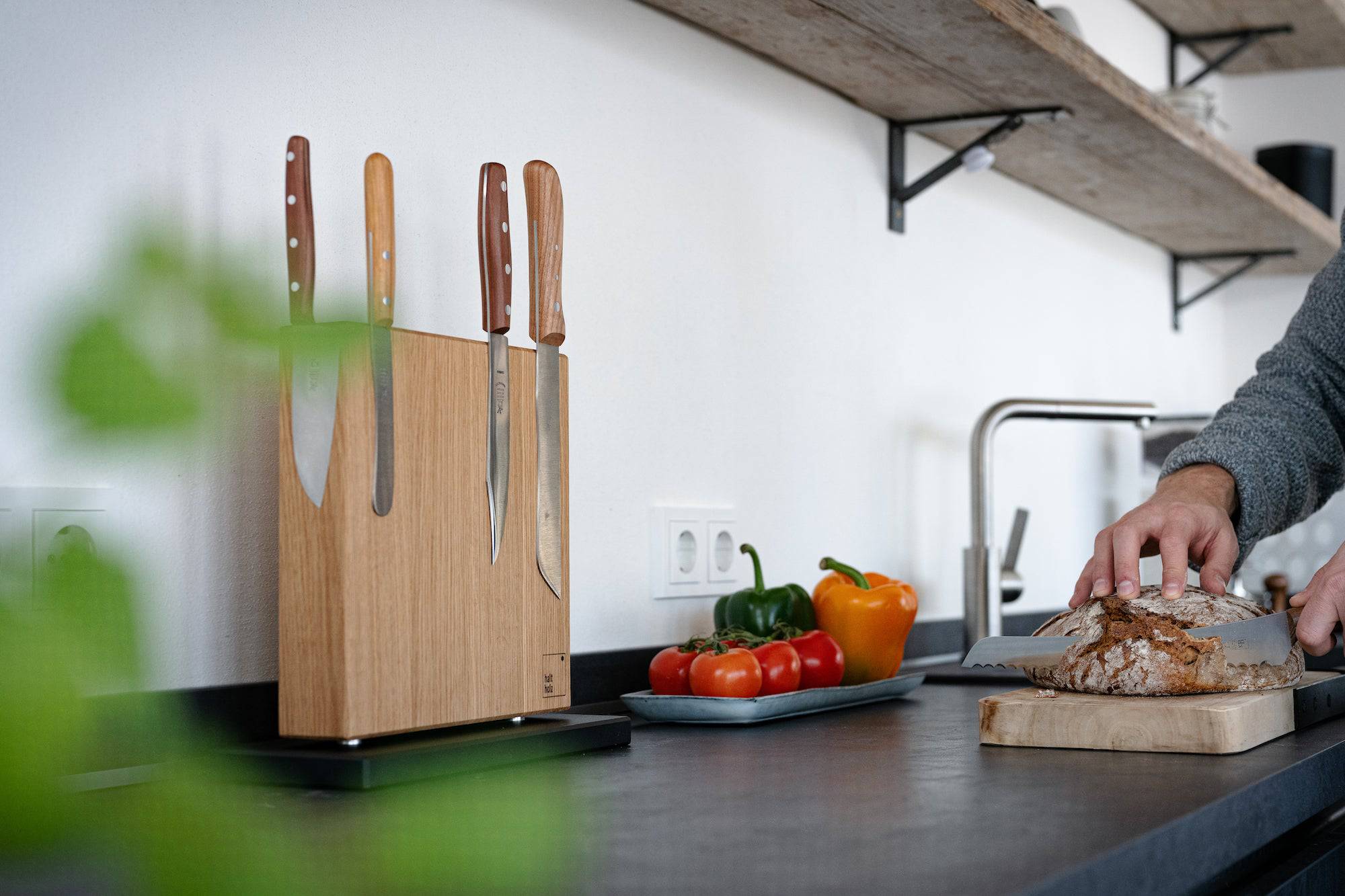 Eiche massiv magnetischer Messerblock mit schwarzem Sockel an einer Wand in einer neuen Küche