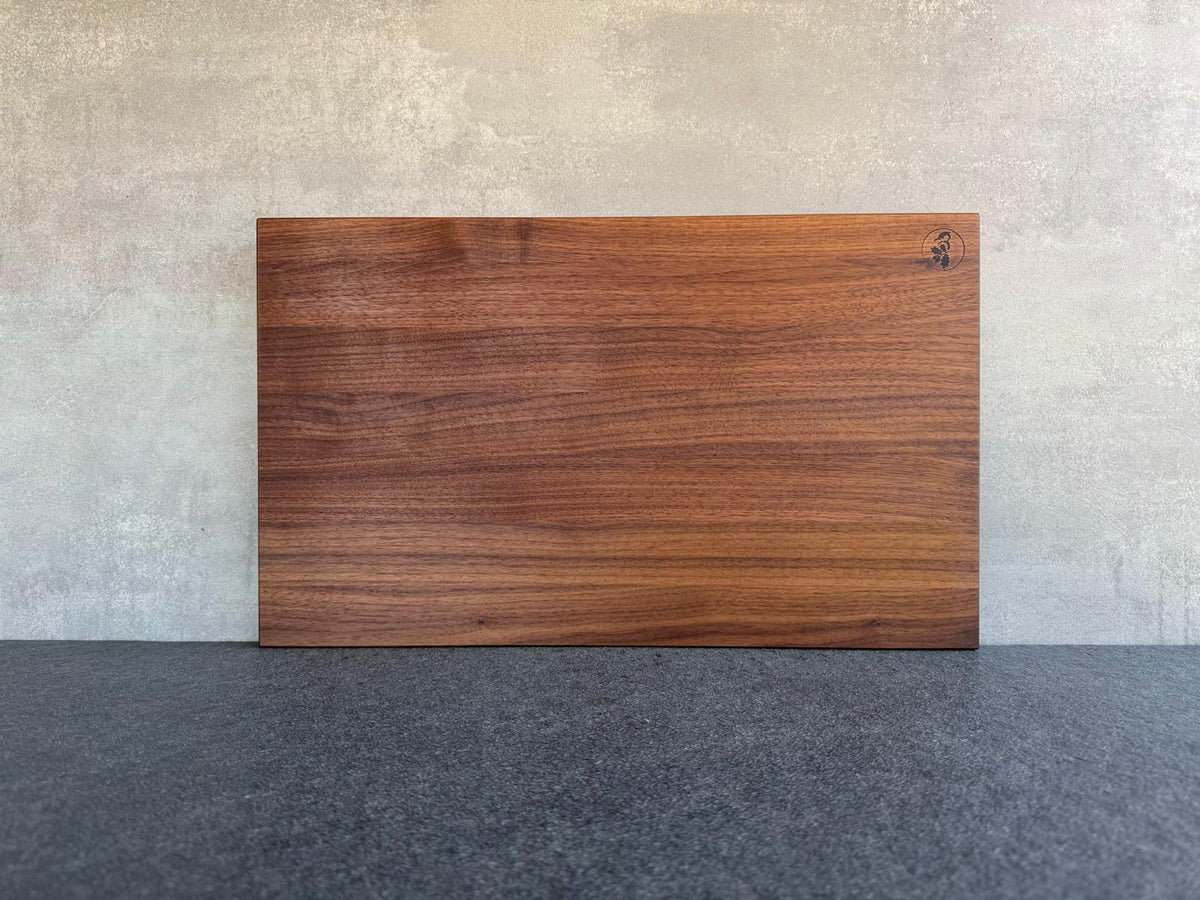 Dickes Schneidebrett aus massivem Nussbaum Vollholz. 45 cm breit mit geraden Kanten.