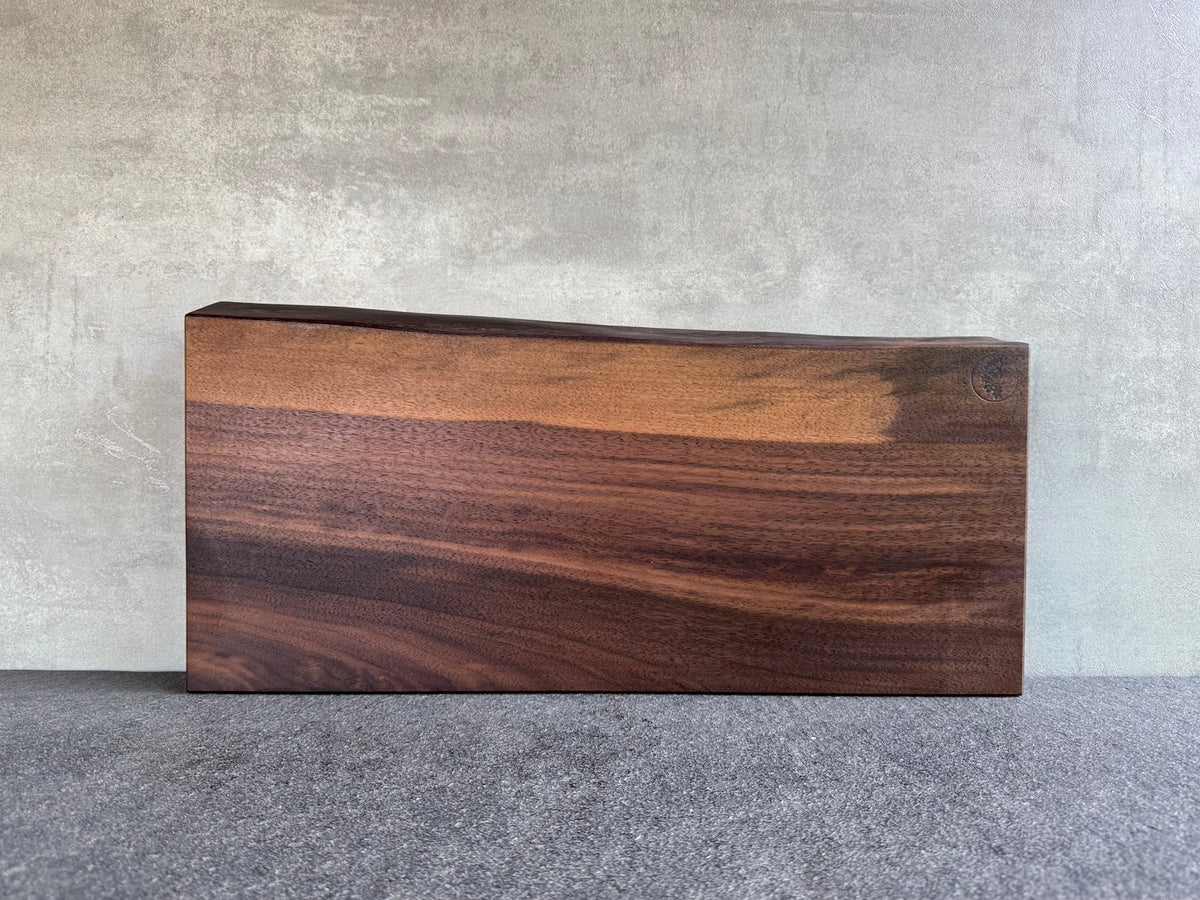 Vollholz Schneideblock aus massivem Nussbaum, über 50 cm breit, mit einer Baumkante.