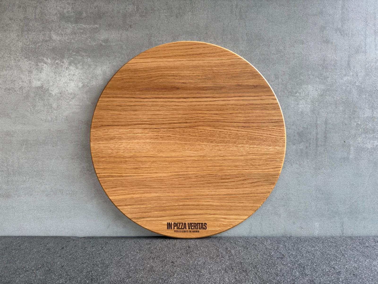 Rundes Pizzabrett aus Eichenholz mit feiner Gravur „In Pizza Veritas“.
Erhältlich in 35 cm Durchmesser.
