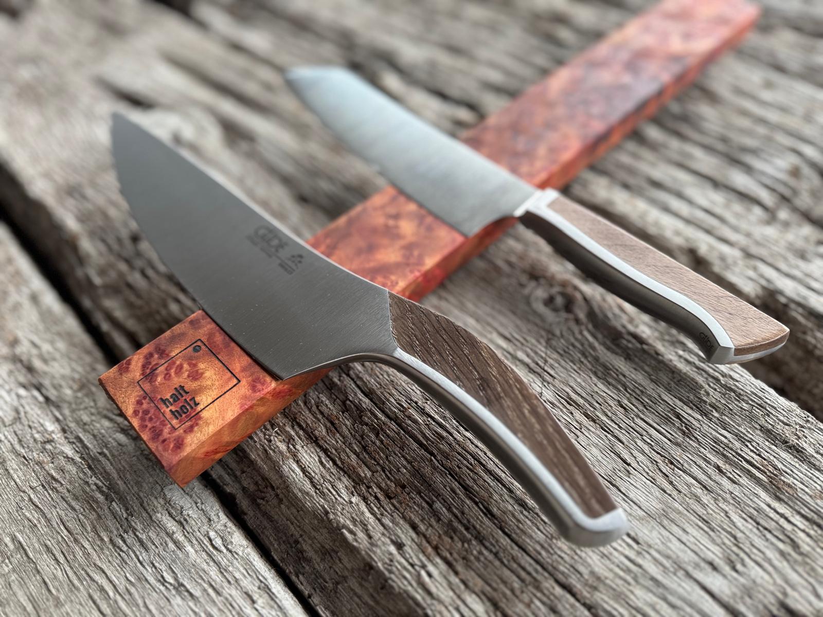 Rötlich orangener Messerhalter aus duftenden Kampfer mit Güde Kochmessern. 