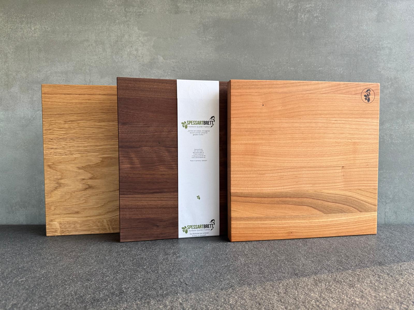 3 verschieden Holzarten in der Form eines quadratischen Schneidebrettes oder Brotbrettes.