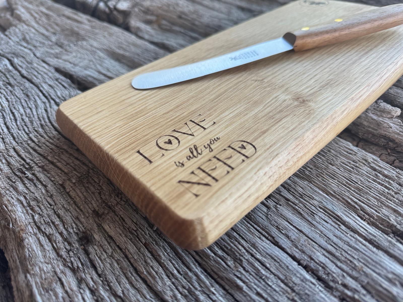 Love is all you Need-Gravur bei einem Holzbrett.