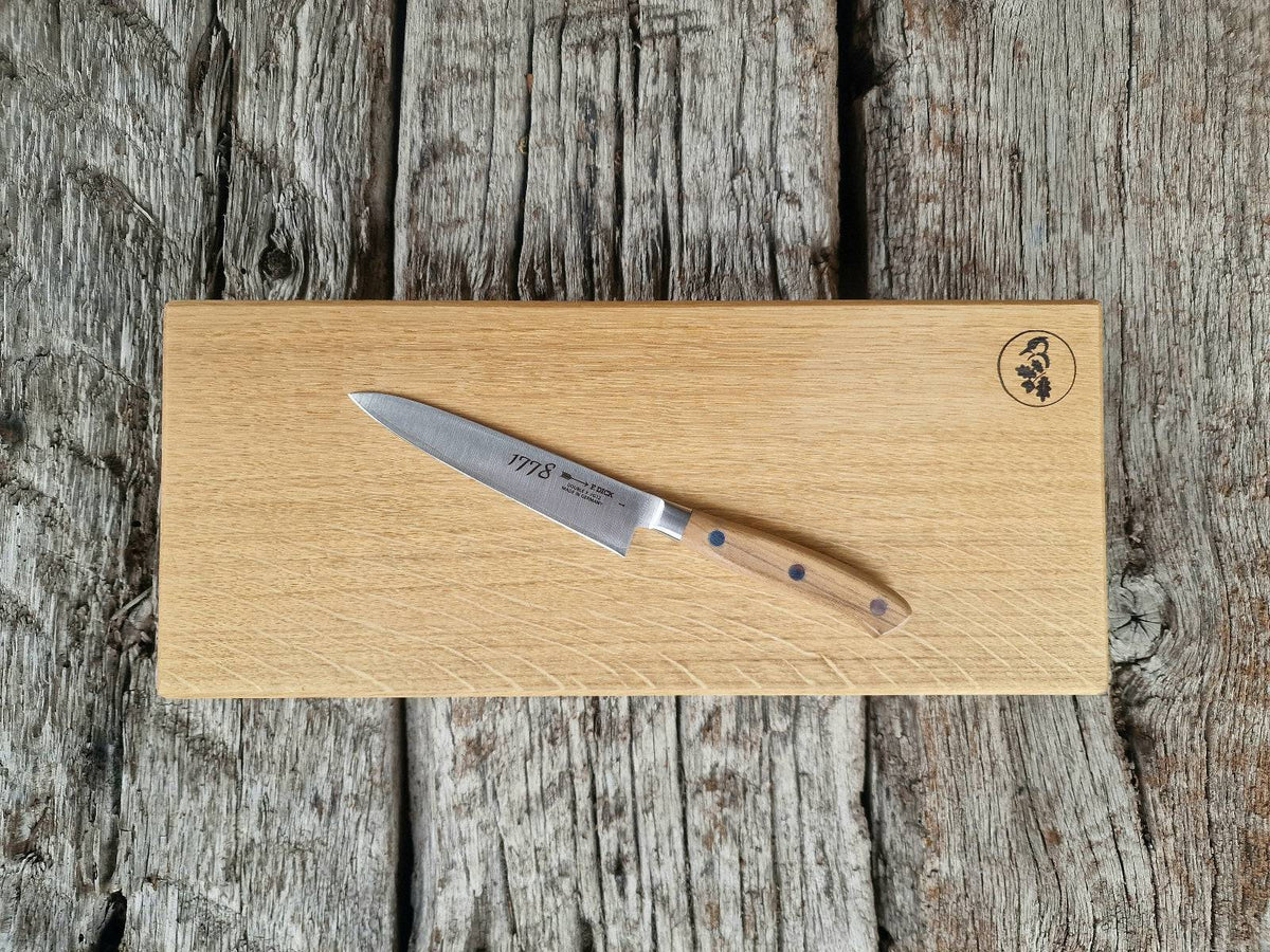 Brotzeitbrett mit 2 schrägen Kanten auf alten Eichenbalken. Dekoriert mit einem DICK Officemesser 1778.