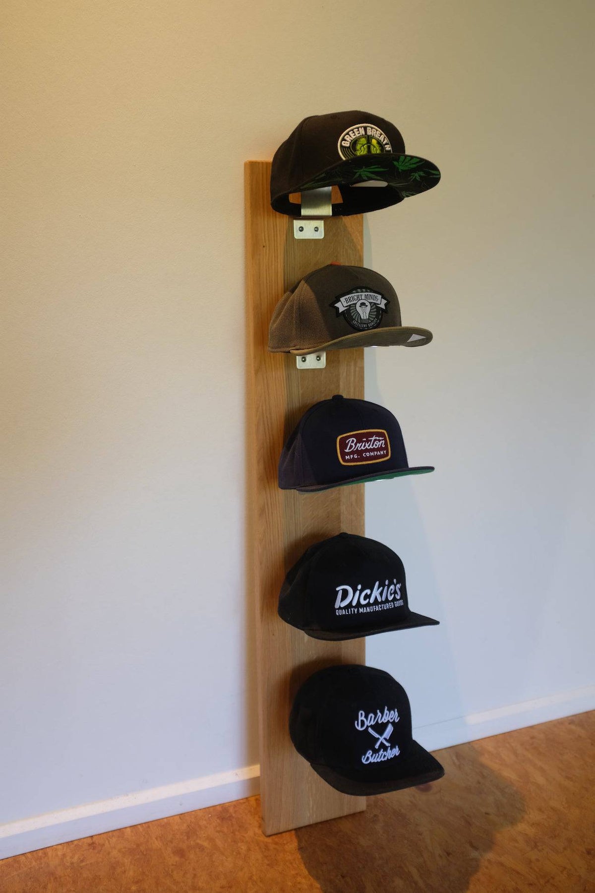 Kappenhalter aus Eichenholz mit Edelstahl Haltern und 5 Baseball Caps.