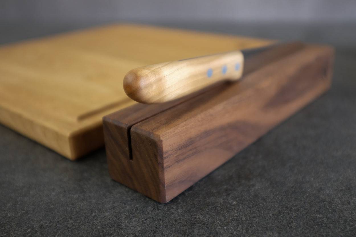 Neben einem Brotbrett. Praktischer Messerhalter mit einem Brotmesser dekoriert.