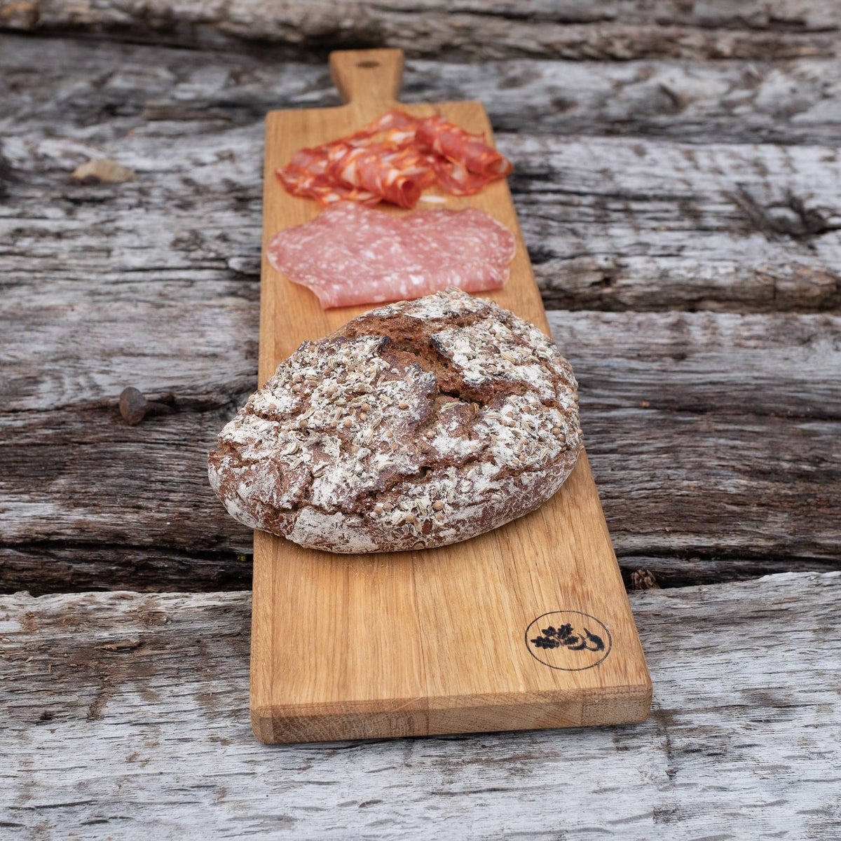 Eiche Servierbrett mit einem Laib Brot und Salami.